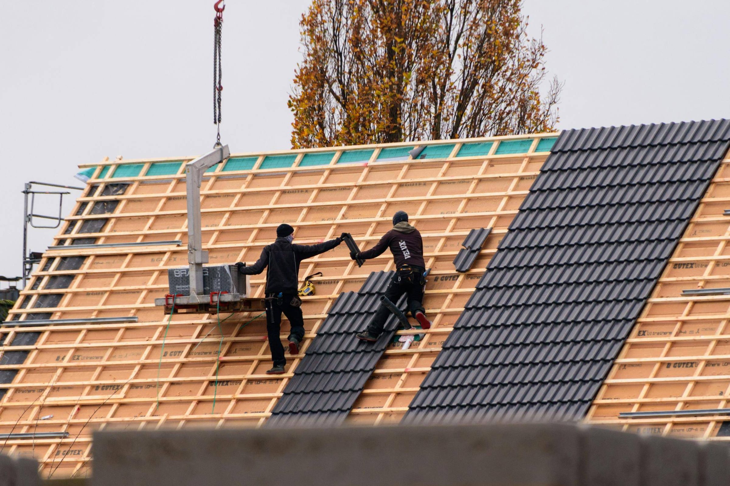 Dachdecker beim Eindecken eines Steildachs (Beispielbild)