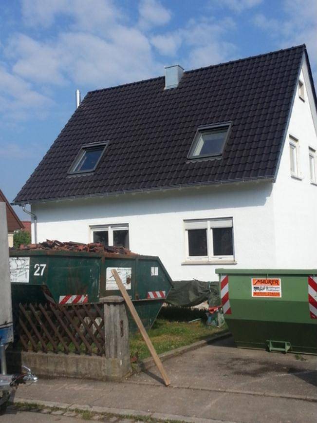 Einfamilienhaus mit neu eingedecktem schwarzem Ziegeldach und zwei Dachfenstern